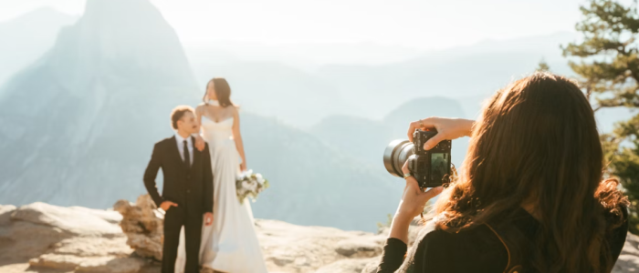 Image of woman taking photo for a married couple.
